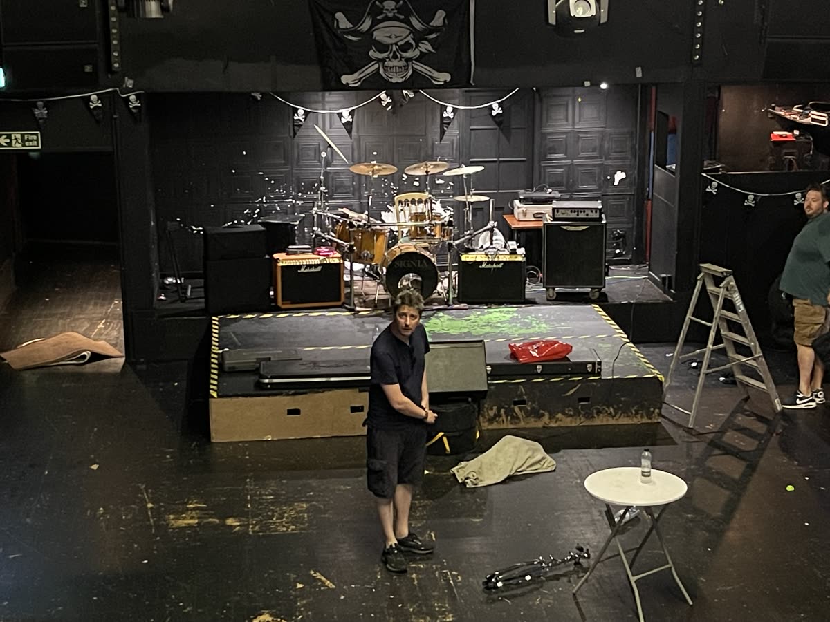 A stage being set up beneath pirate flags