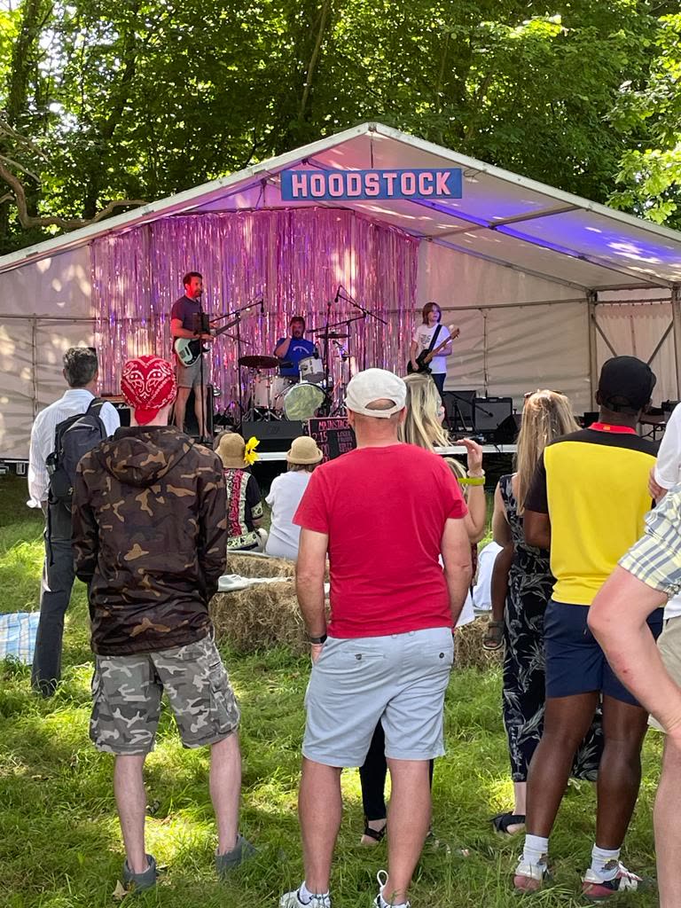A band performing beneath the Hoodstock sign